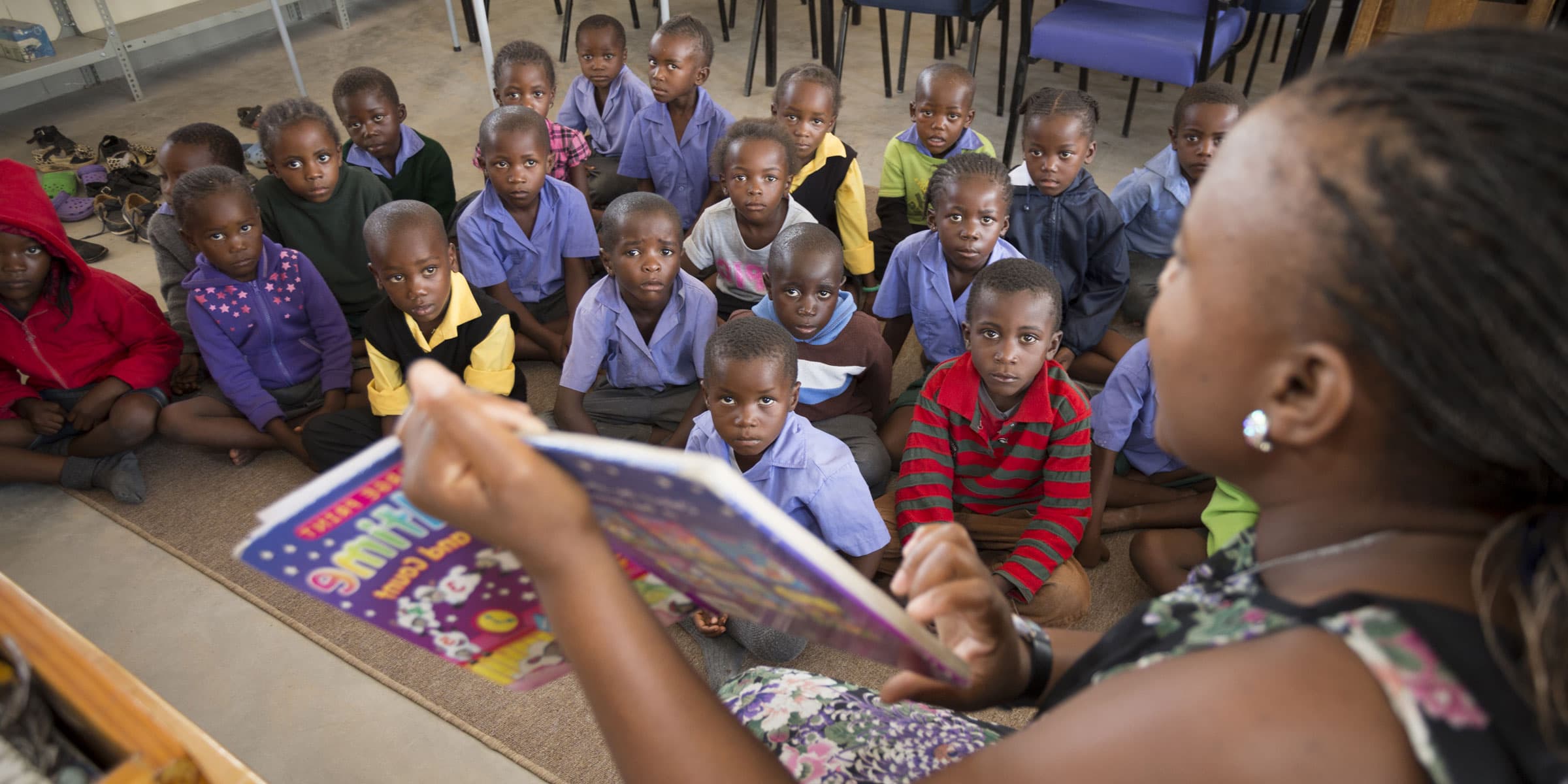 A teacher reading to a circle of learners